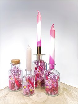 Flesjes gevuld met droogbloemen in rood en roze