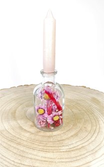 Klein flesje gevuld met droogbloemen in roze en rood